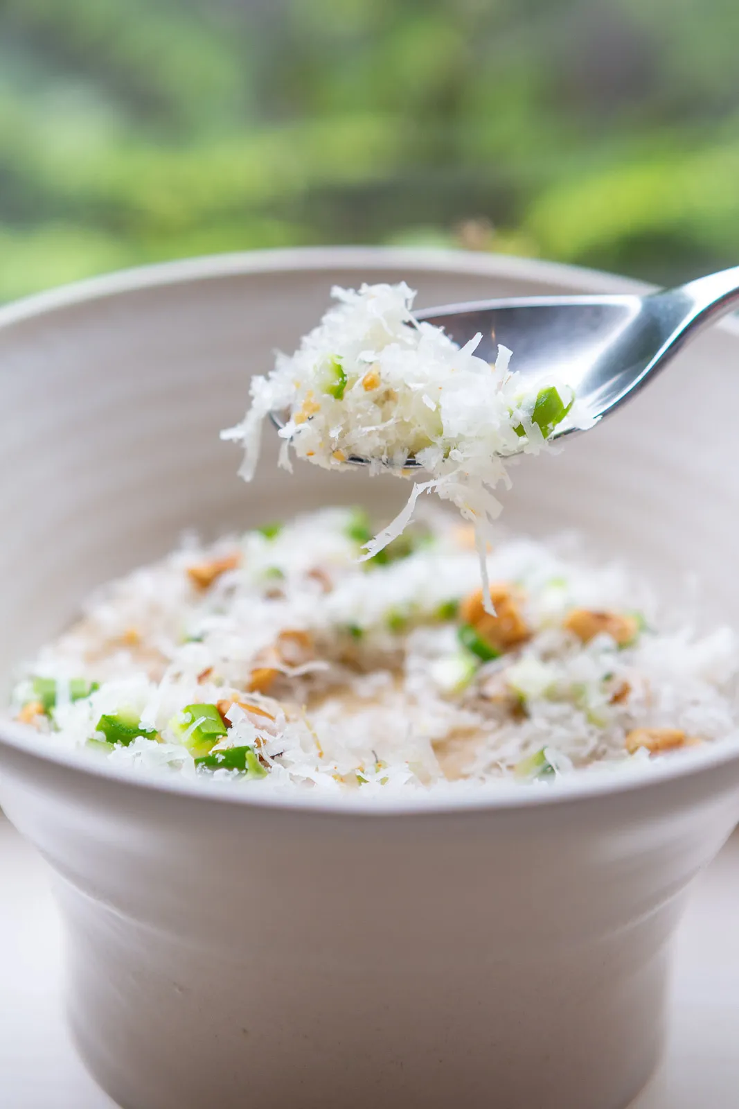 A round white bowl with a creamy parmesan top, a silver spoon digging into the centre at Sat Bains
